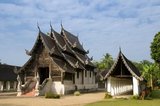 Wat Ton Kwen (วัด ต้น เกว๋น), more formally known as Wat Inthrawat (วัด อินทราวาส), means ‘Temple of Sugar Palms’ in kham muang or Northern Thai, and sure enough the rustic temple, set in a small village amid verdant rice paddies, is surrounded by tall and elegant sugar palms.<br/><br/>

Built at the start of the reign of Chao Kawilorot (1856-70) in 1856, Wat Ton Kwen is among the finest and purest examples surviving of traditional 19th century wooden Lan Na temple architecture. No doubt because of its small size and relative isolation, it has been spared the ‘improvements’ and other indignities suffered not just by most of its contemporary structures, but also by much older Lan Na religious buildings.<br/><br/>

The most distinctive features at Wat Ton Kwen are the typically Lan Na viharn or gabled assembly hall, and an unusual cruciform, four-porch mondop or open-sided pavilion.